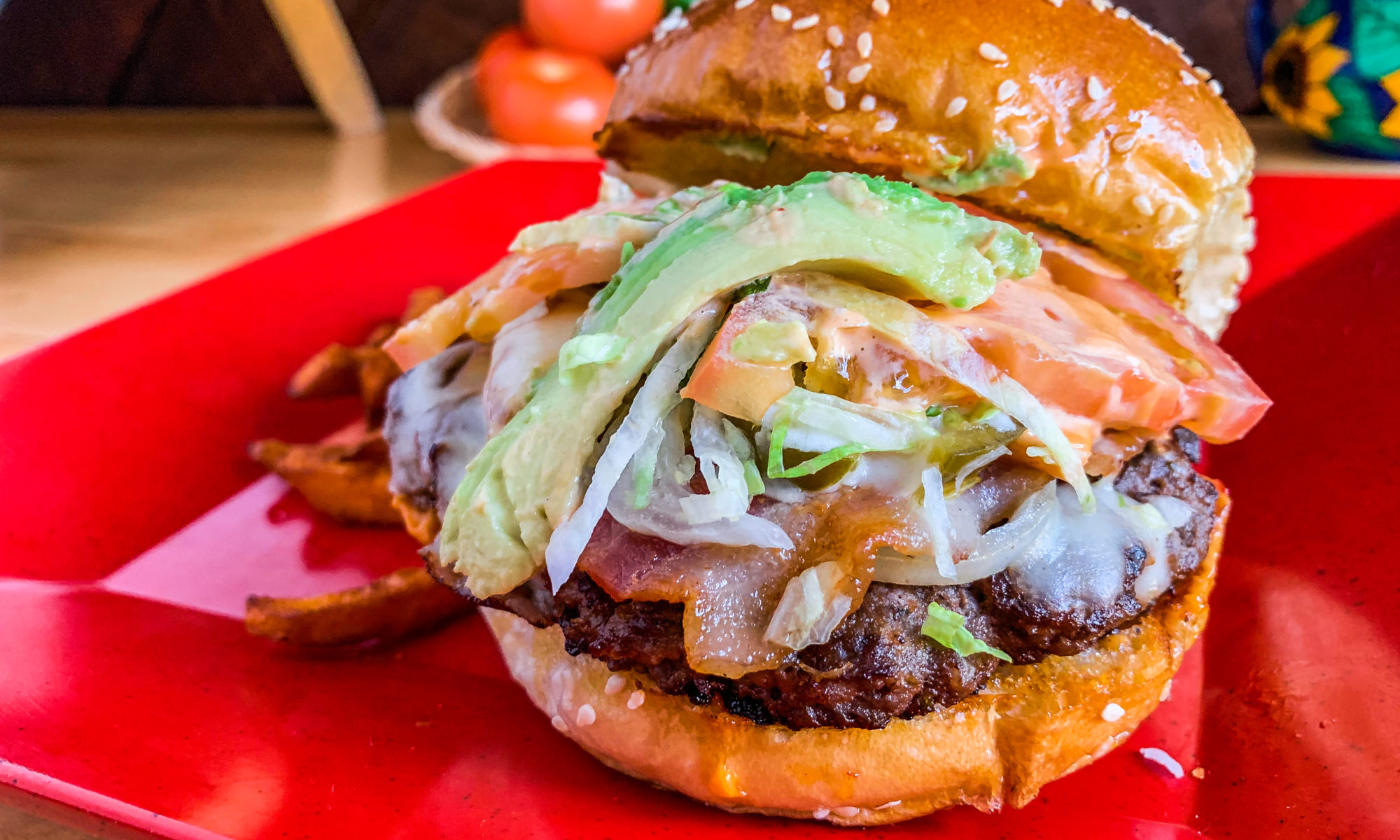 Mexican burger with avocado, bacon and tomato